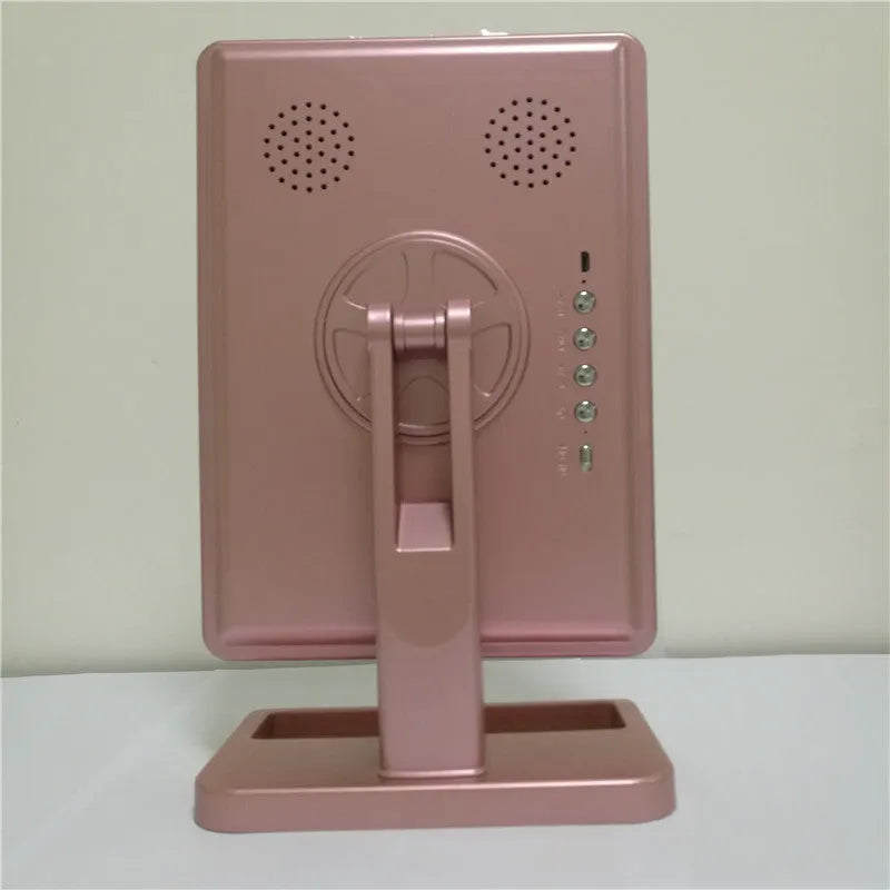 Pink touch screen makeup mirror with ring of 20 LED lights and built-in Bluetooth speaker on a dressing table.