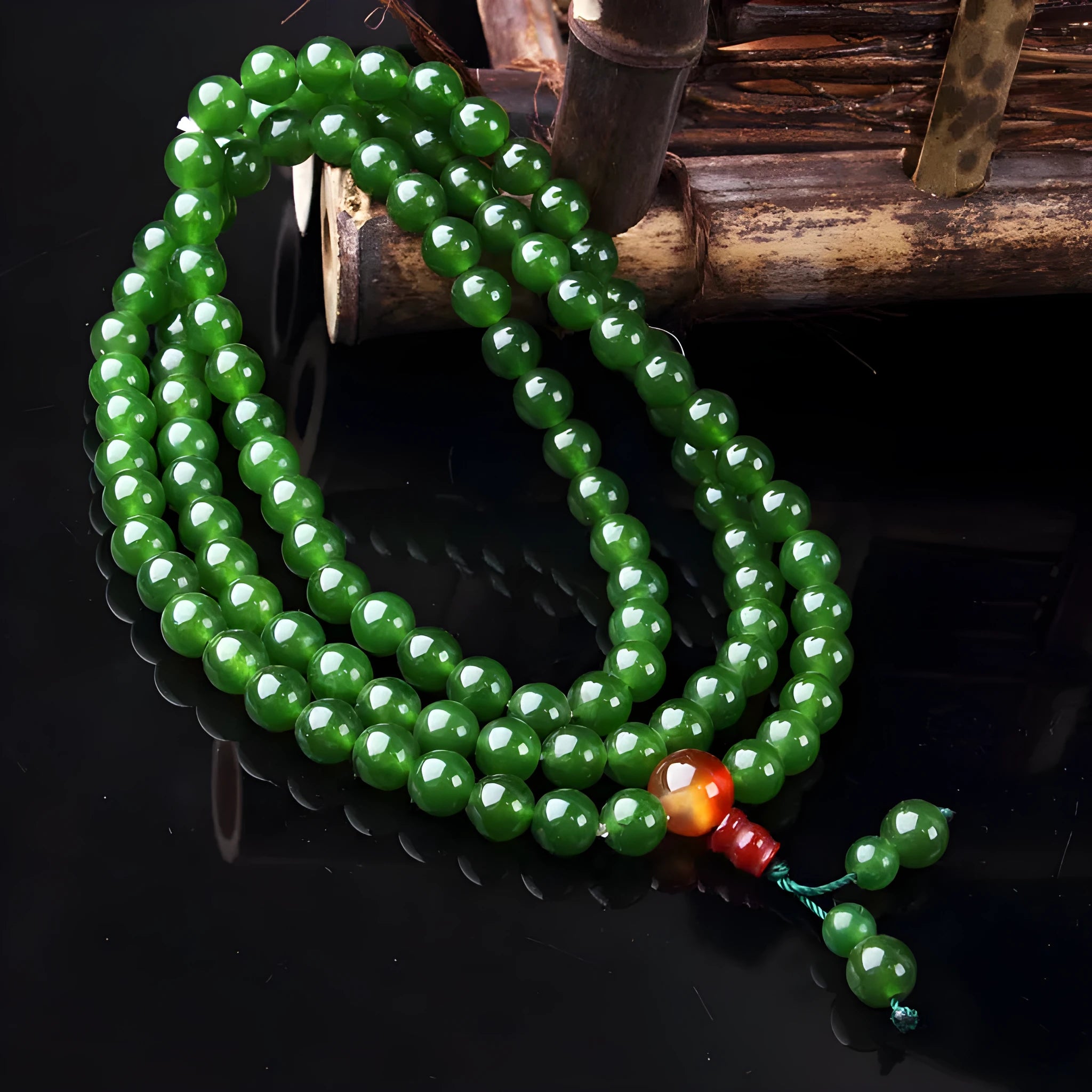 Green spinach quartz rock jade rosary bracelet with Buddha head pendant on a wrist.