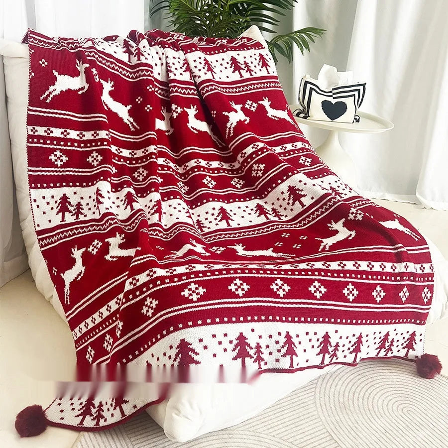 Personalised Christmas blanket with snowflake or reindeer pattern on a sofa.