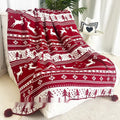 Personalised Christmas blanket with snowflake or reindeer pattern on a sofa.