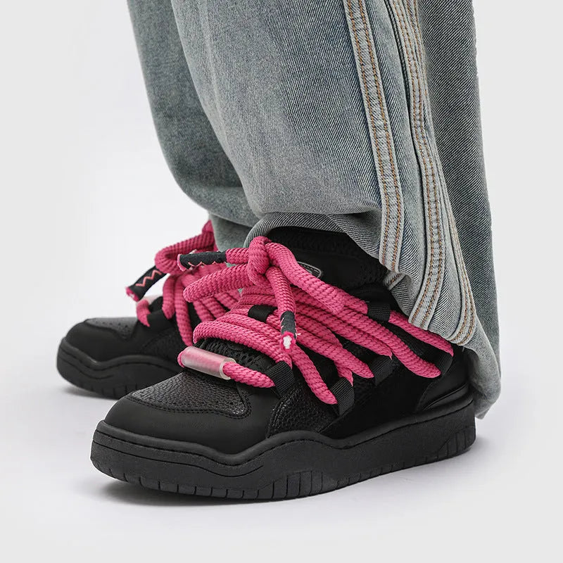Pair of thick-soled casual lace-up trainers in a solid colour on a white background.