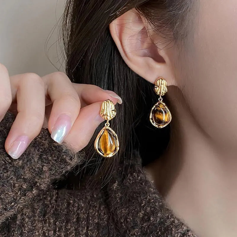 Set of three geometric alloy earrings with tassel detailing in gold, amber and tiger eye colours