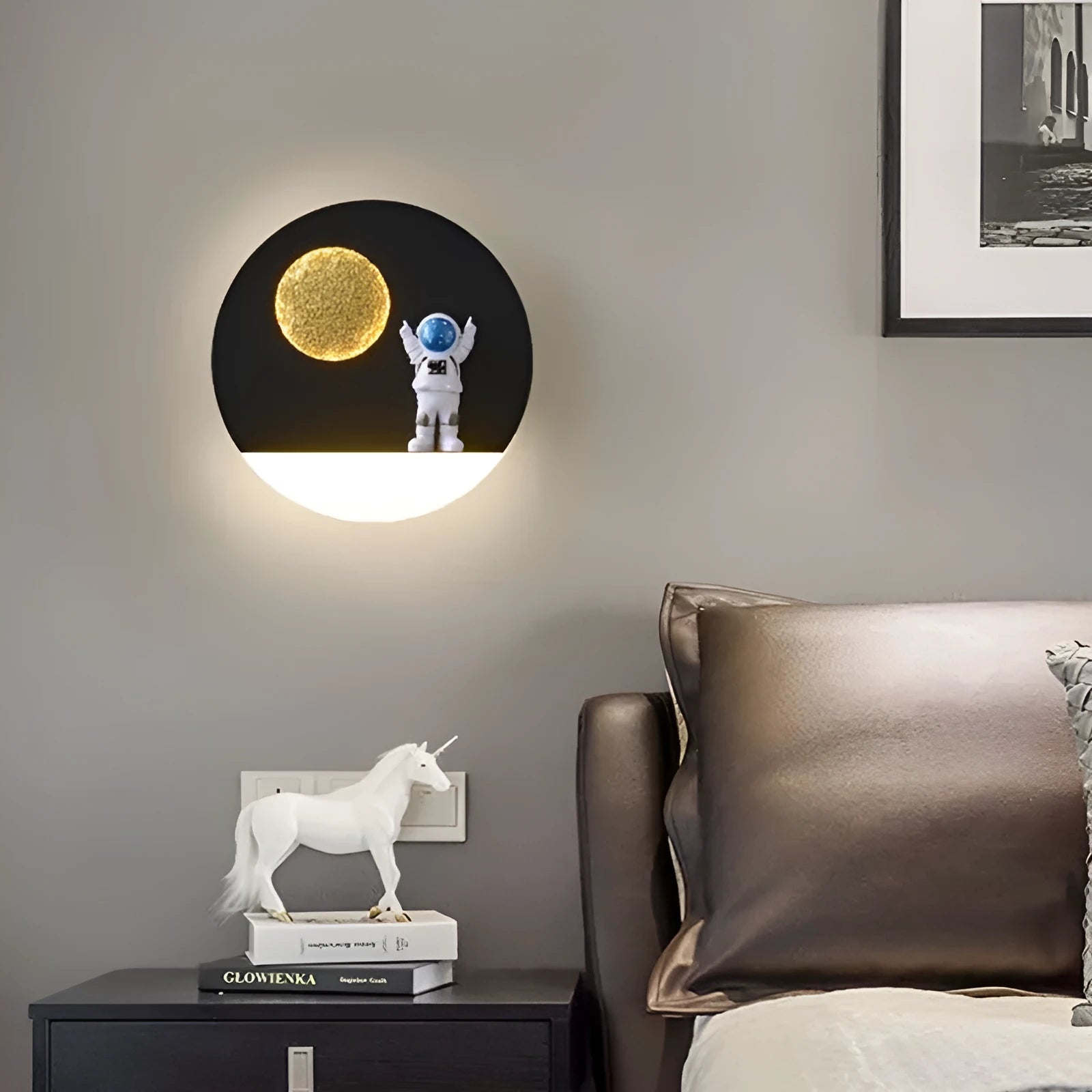 Astronaut-shaped wall lamp with a small shelf, shown in a choice of round or square, black or white finishes.