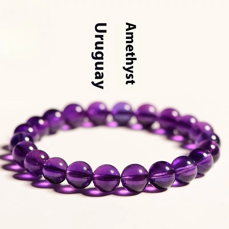 Scattered natural Uruguay amethyst beads for bracelet making in various sizes and purple shades.