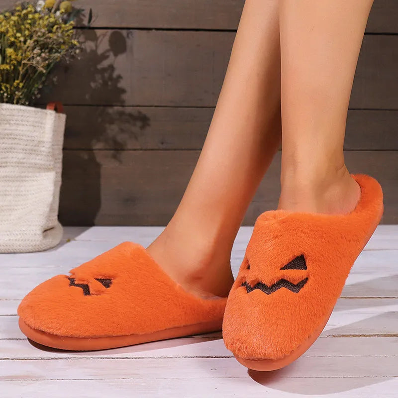 Orange Halloween pumpkin-themed plush indoor slippers with a coral velvet upper and non-slip PVC sole.