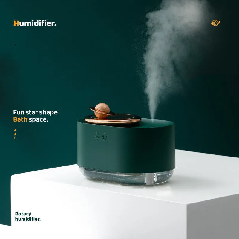 Green rotating planet-shaped USB humidifier with night light on wooden desk