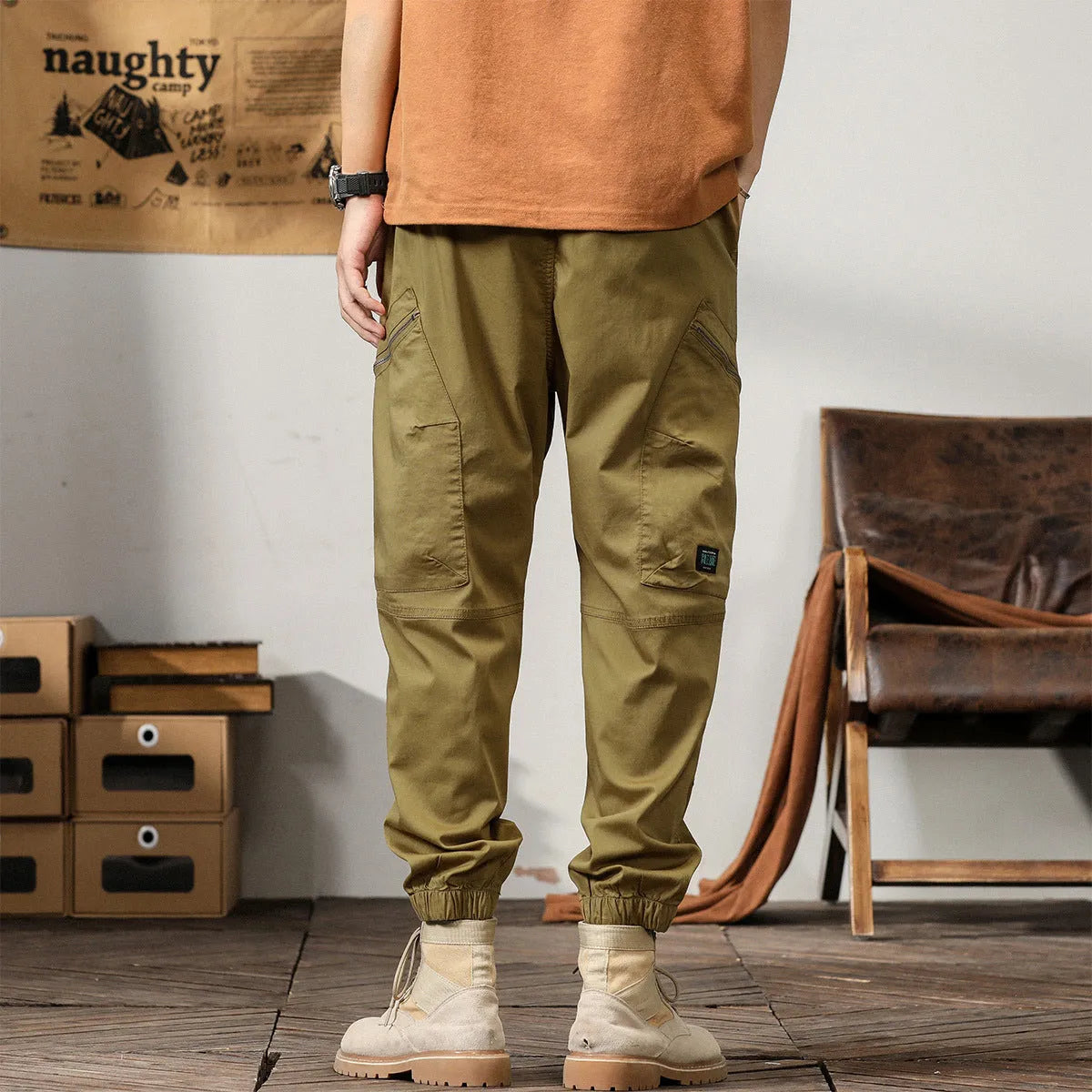 Man wearing khaki loose-fit cotton harem pants with tapered ankle-banded legs.