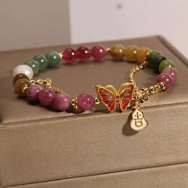 Close-up of a women's agate bracelet with a tourmaline butterfly gourd pendant in natural jade colour.