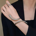 Gold exaggerated twisted winding open snake ring and bracelet jewellery set on white background.