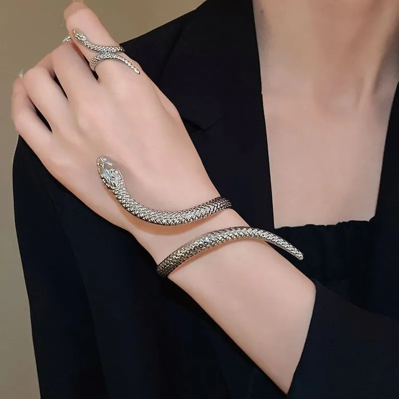 Gold exaggerated twisted winding open snake ring and bracelet jewellery set on white background.
