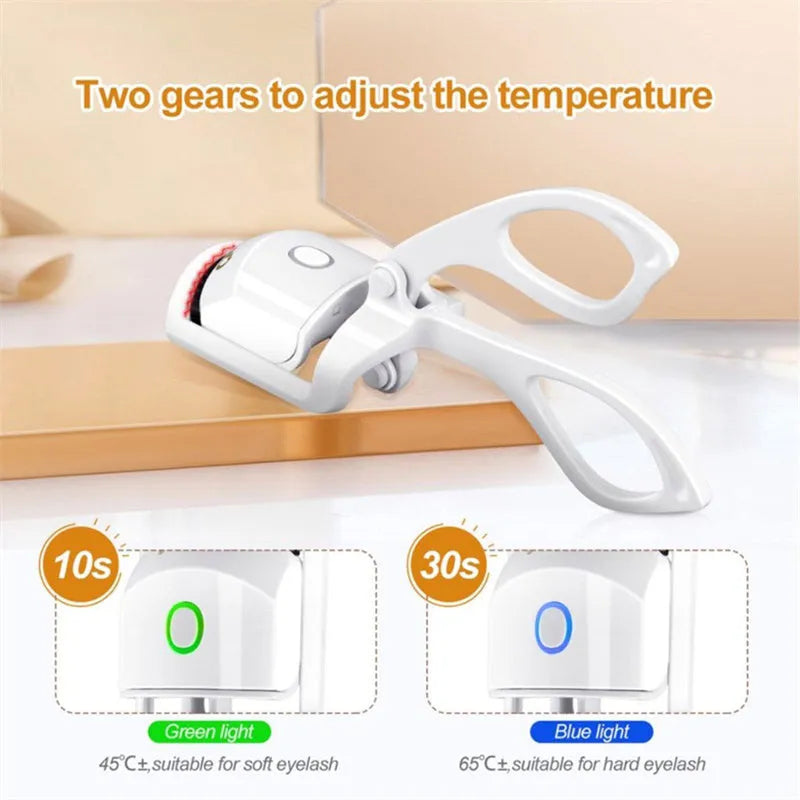 White USB rechargeable heated eyelash curler with dual temperature settings shown on a pink background.