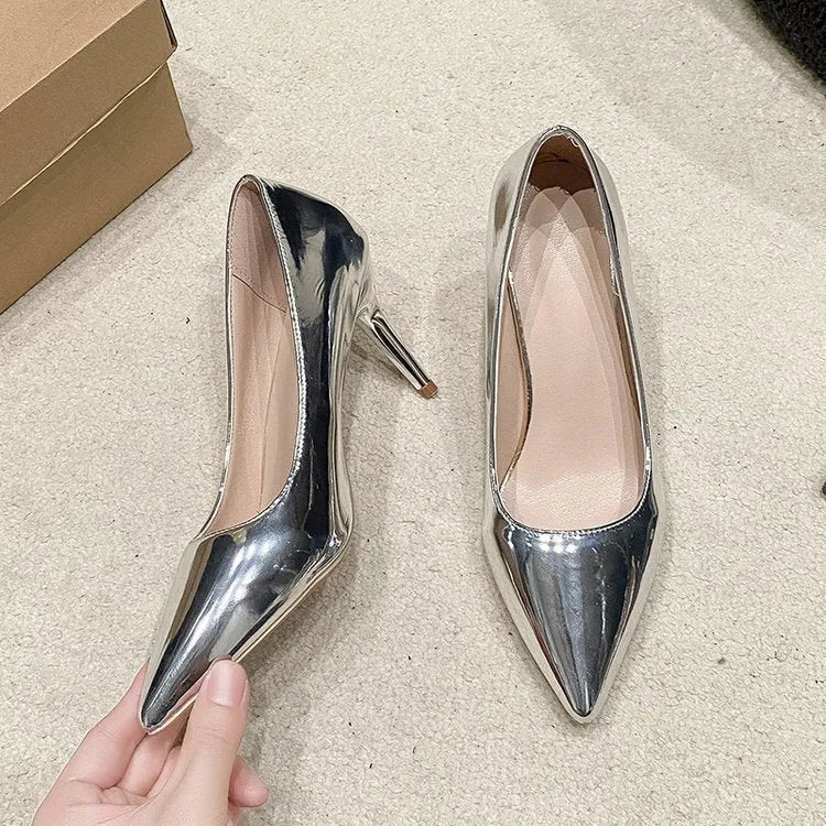 Gold metallic women's pointed toe slip-on pump with a tall stiletto heel on a white background.