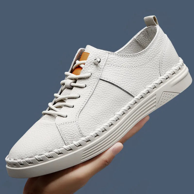 Men's beige casual leather sneakers with mesh lining and round toe stitching detail.
