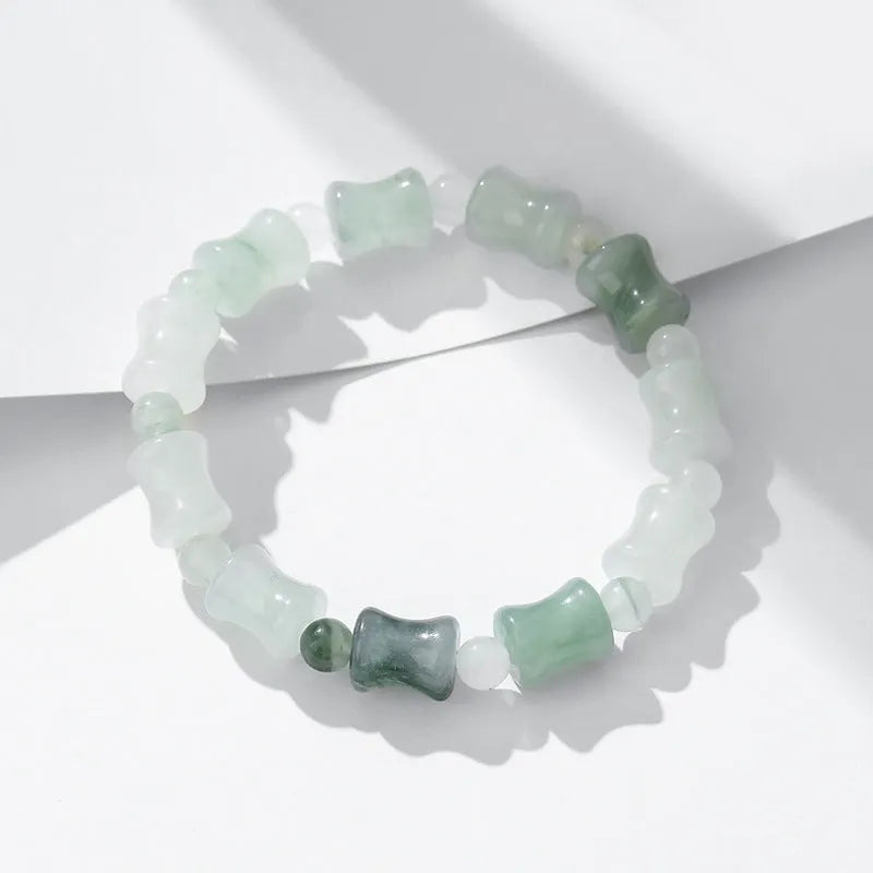 Simple beaded bracelet with chalcedony and coconut shell beads, diamond jade piece, and safety lock.