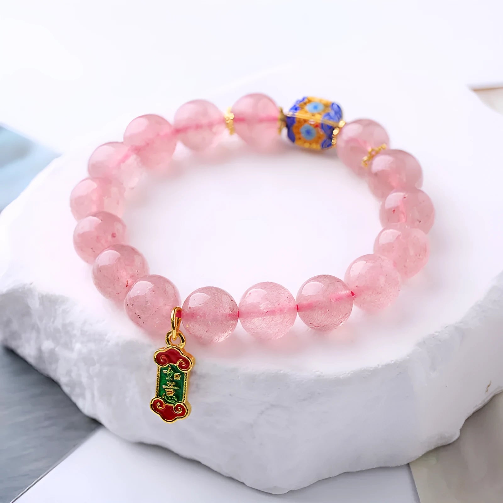 Pink strawberry quartz crystal bracelet with hand-woven construction and traditional Chinese ruyi lucky symbols