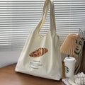 Beige canvas one-shoulder tote bag with printed bread and croissant designs