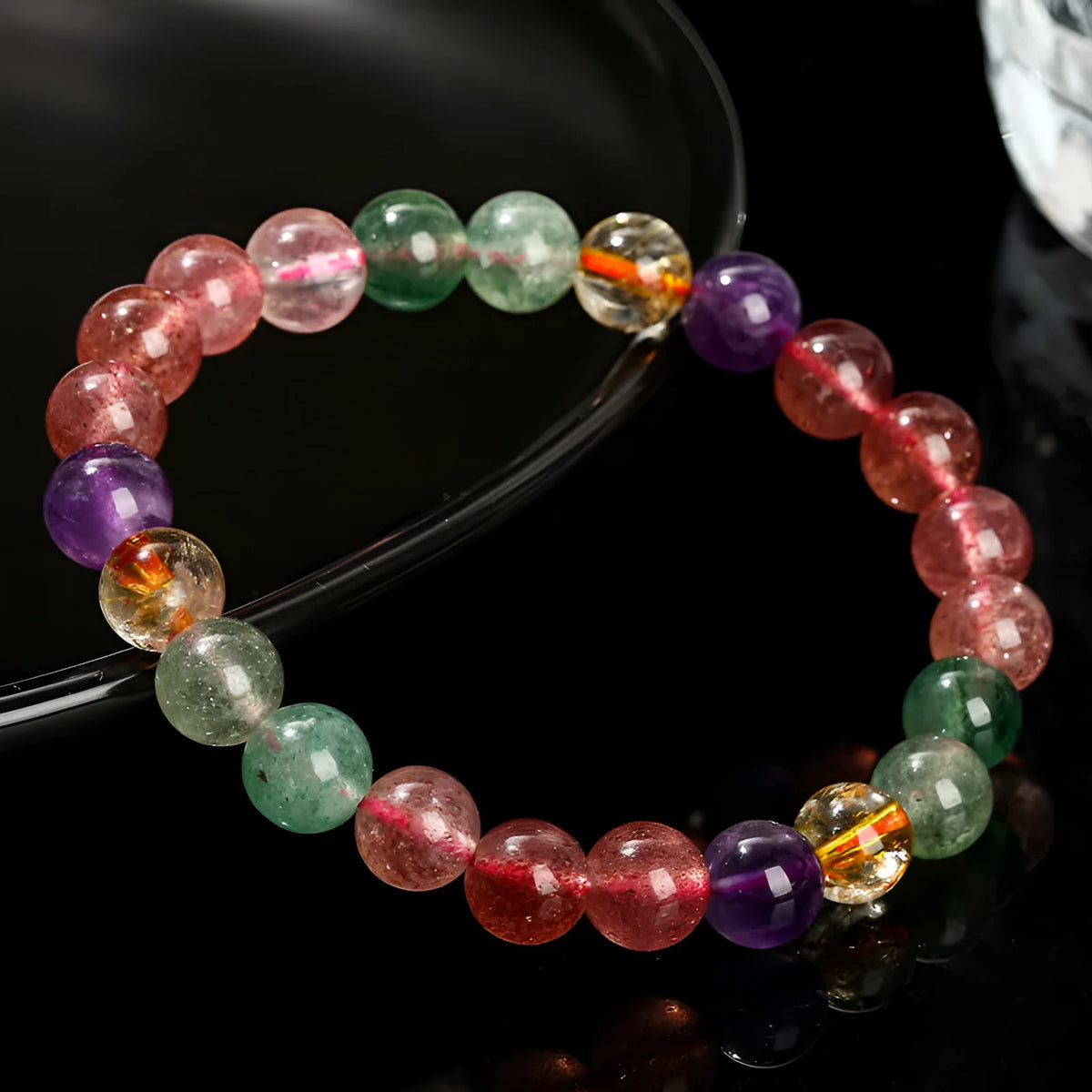 Natural tourmaline colour strawberry quartz bracelet with geometric round beads on a wrist.