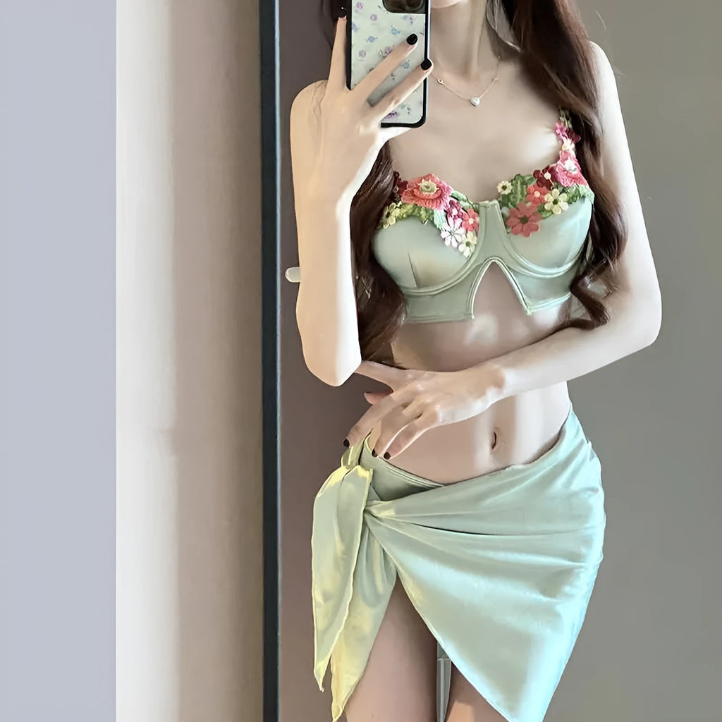 Green women's three-piece bikini set with triangle cup top, briefs, and skirt cover-up