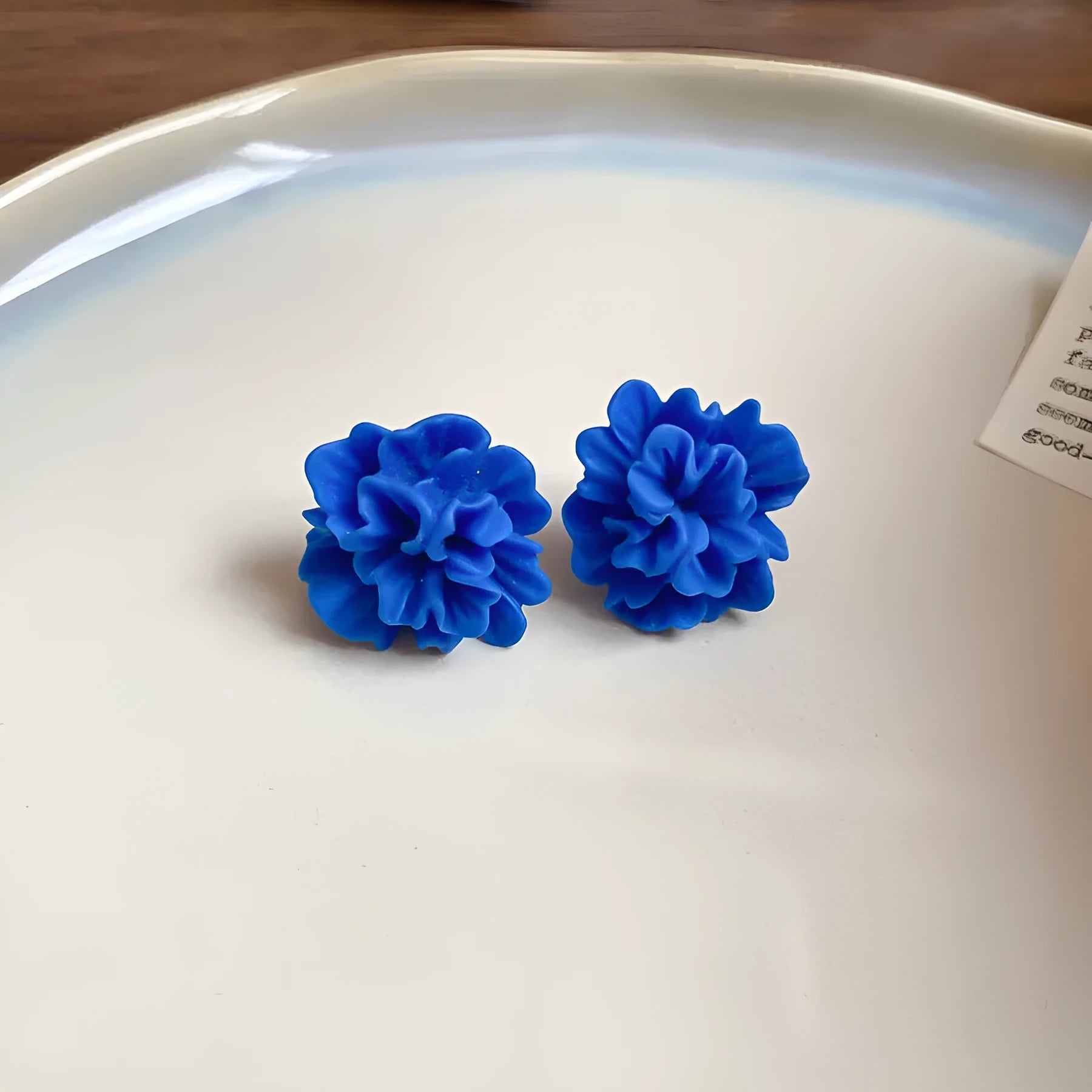 Geometric women's earrings with blue resin flowers on cloth material in silver needle colour