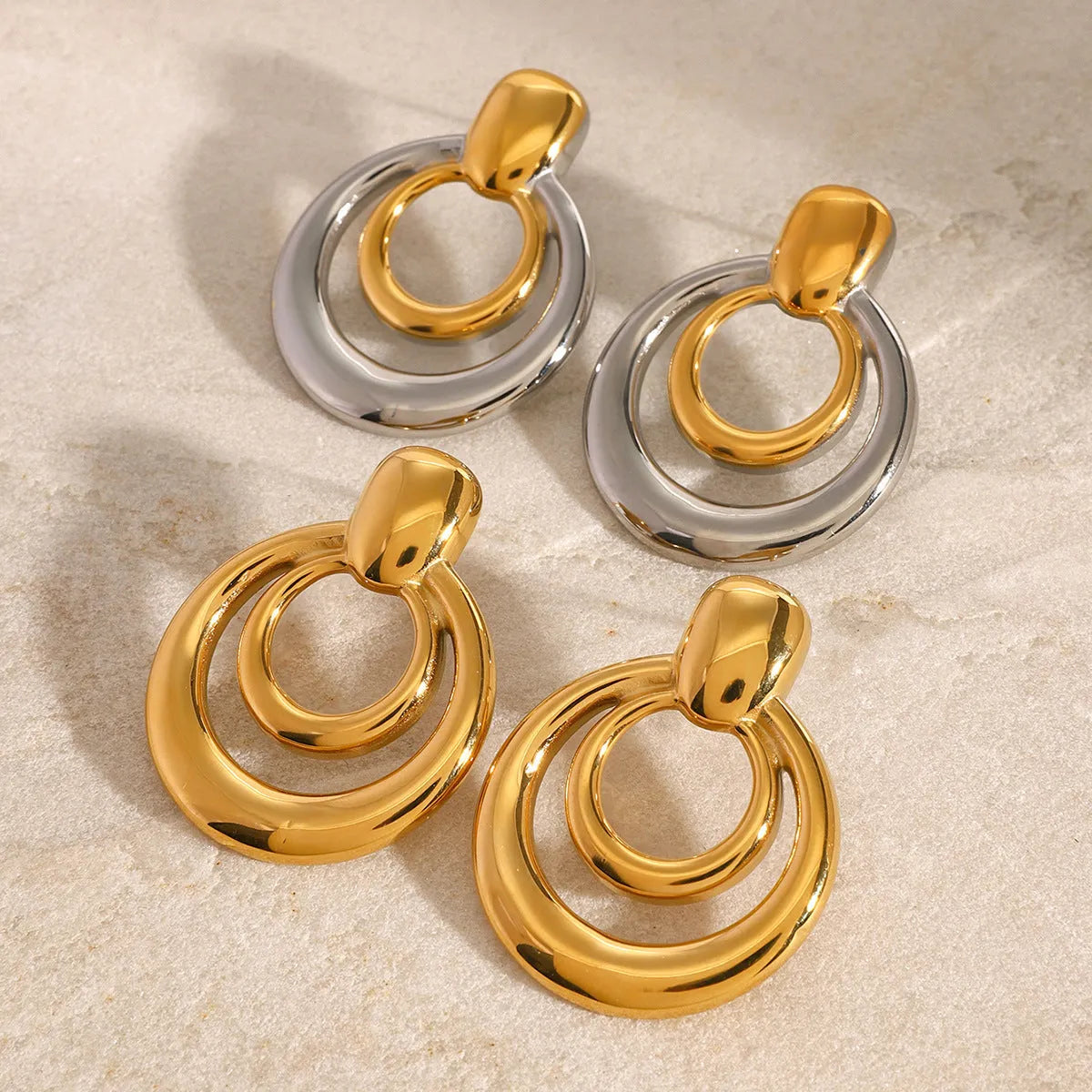 Golden round double layer hollow stud earrings with titanium steel construction and 18k gold plating