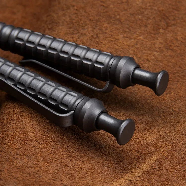 Gunmetal grey titanium tactical pen with push-action decompression mechanism