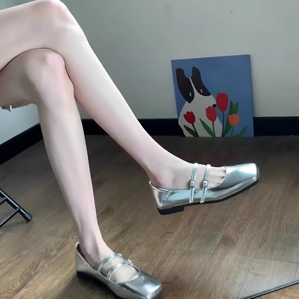 Women's silver leather ballet flats with a cross buckle strap and round toe.