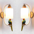 Resin bird wall lamp with iron body, wood accent, and glass lampshade on a wall