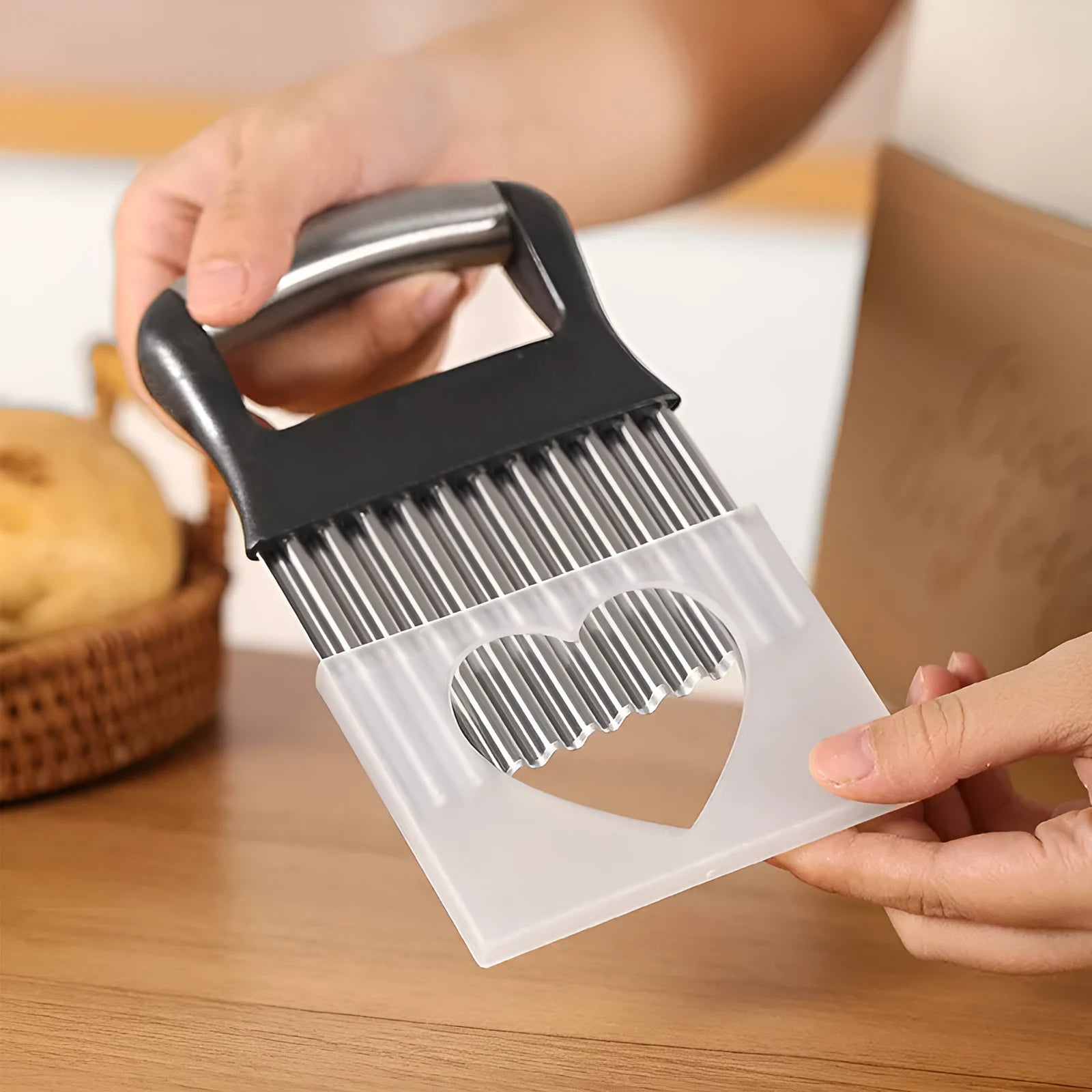 Stainless steel potato wave knife kitchen tool in black on a wooden surface.