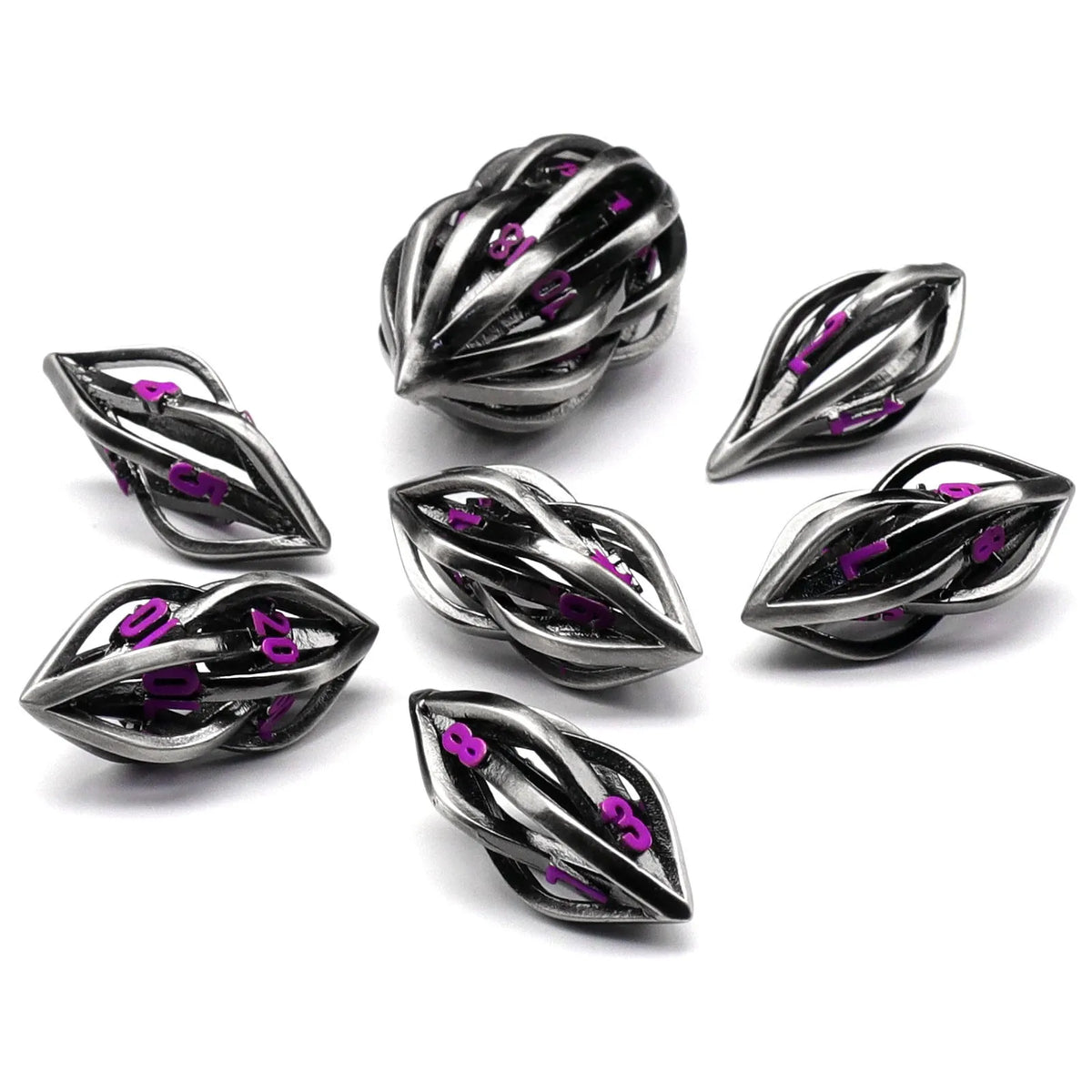 Seven metal melon seed shape dice in antique silver with coloured characters on a surface