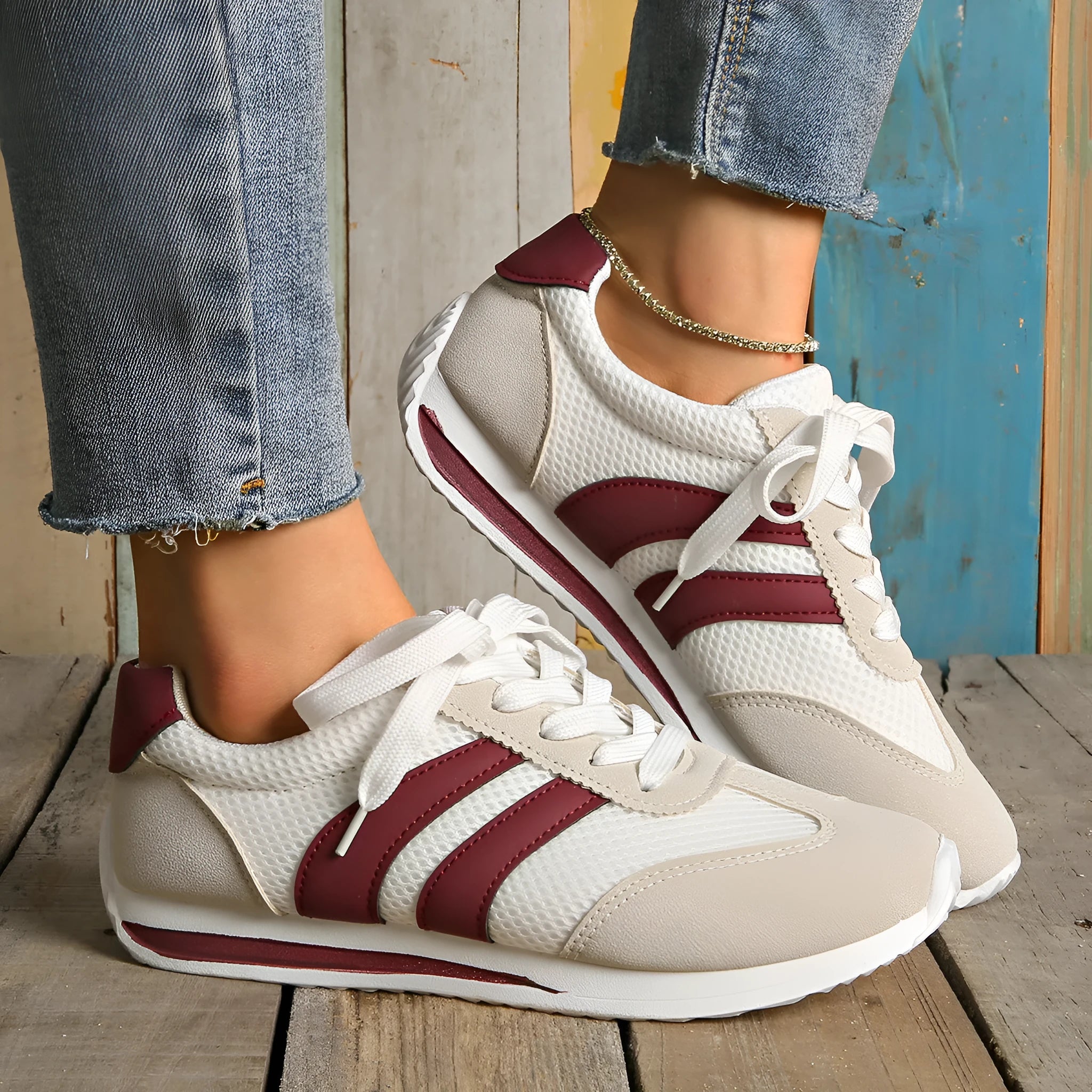 Wine red casual sneakers with cross straps over a breathable mesh and synthetic leather upper.