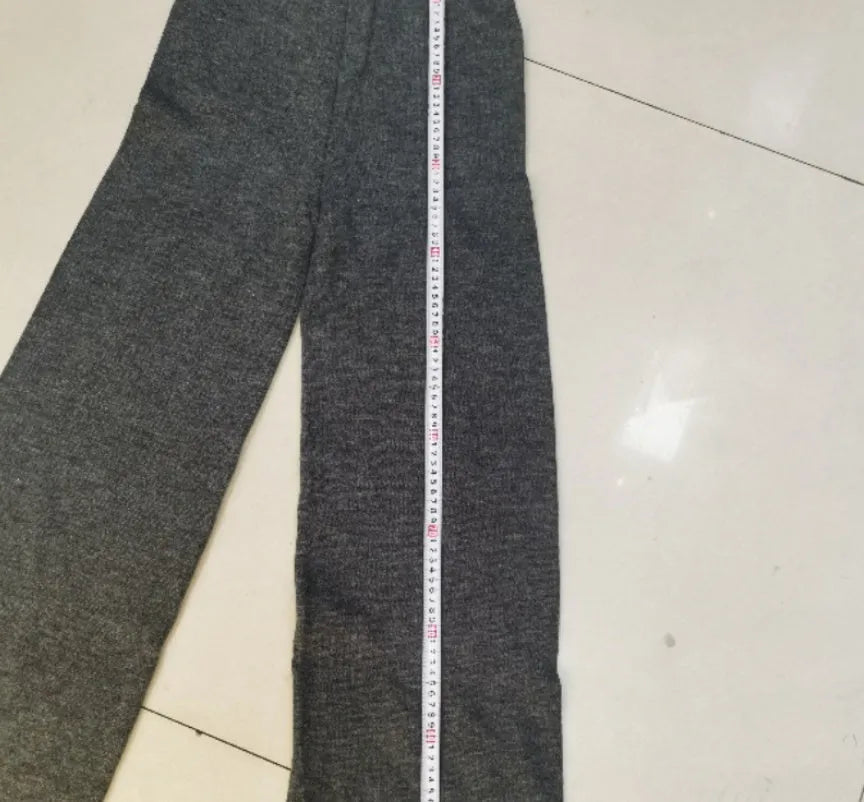 Women's dark grey knit co-ord suit with side-slit sweater top and matching trousers.