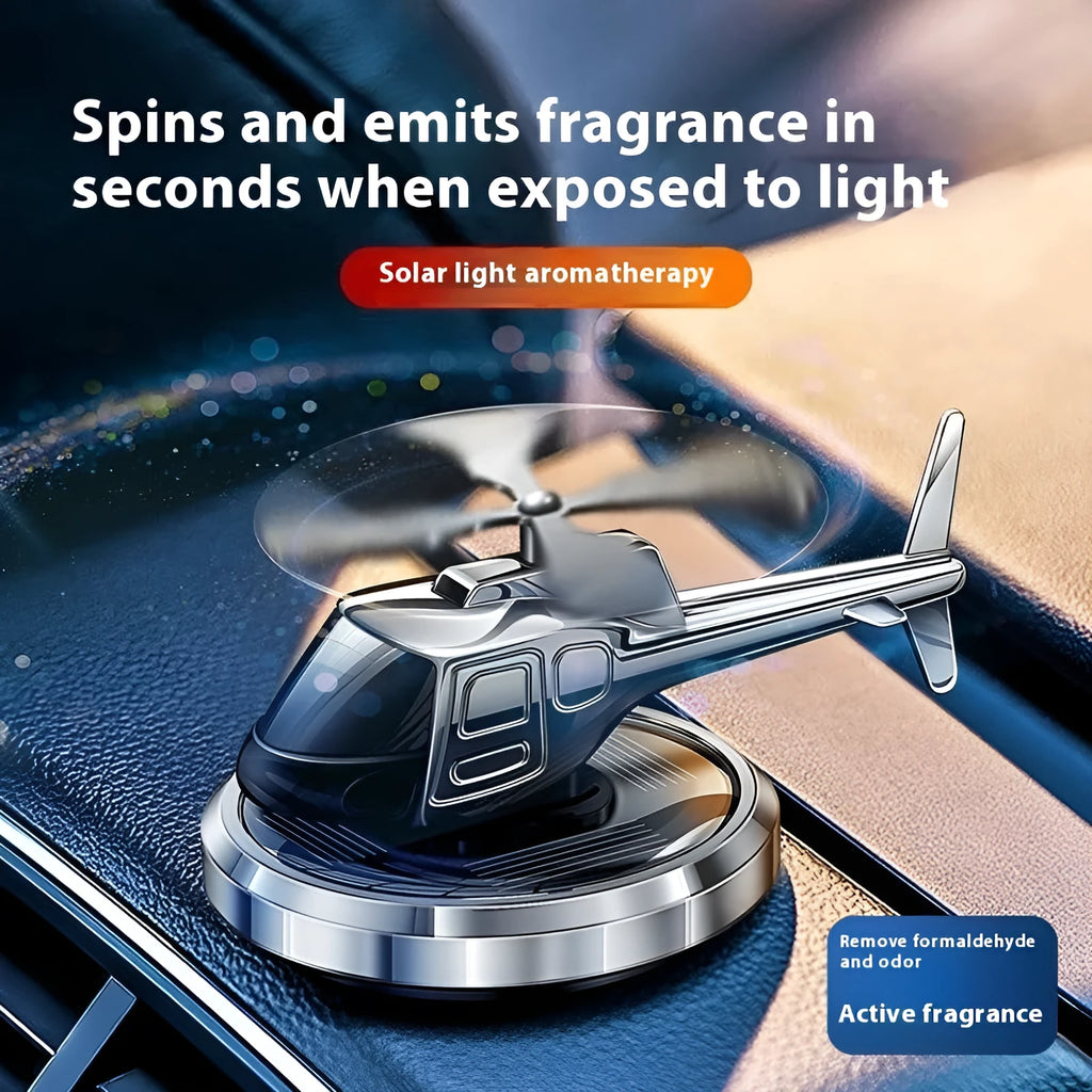 Silver metal solar helicopter car perfume ornament spinning on a car dashboard