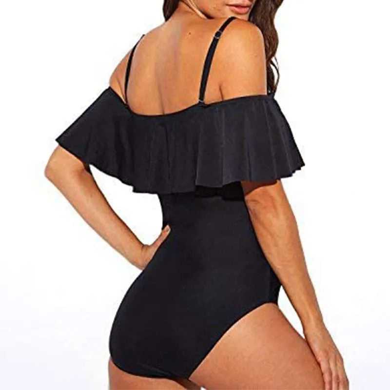 Black women's one-piece swimsuit with side cut-outs and ruffled straps on a tube top.