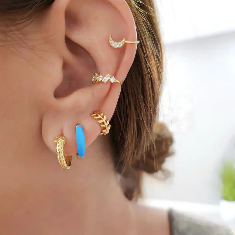 A pair of curved oval epoxy earrings on a U-shaped silver-plated copper base.