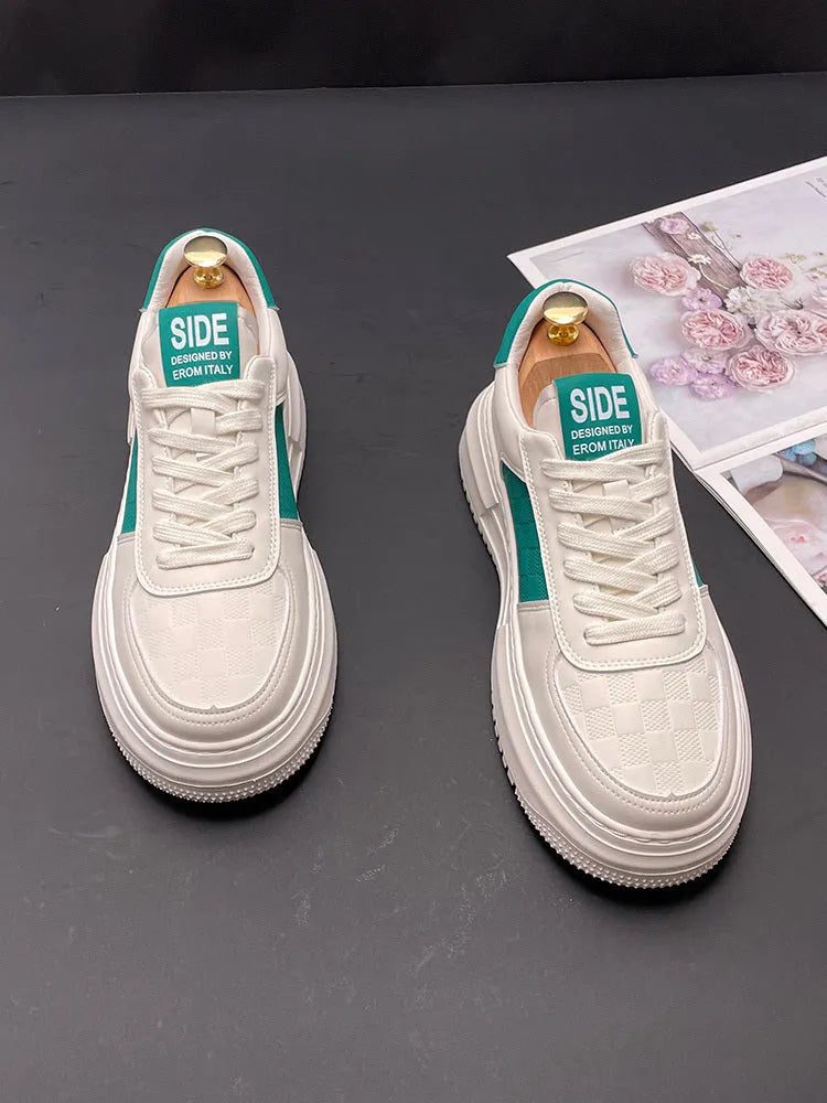 A pair of white, green, and black sports-style casual shoes with a cloth upper and rubber foam sole.