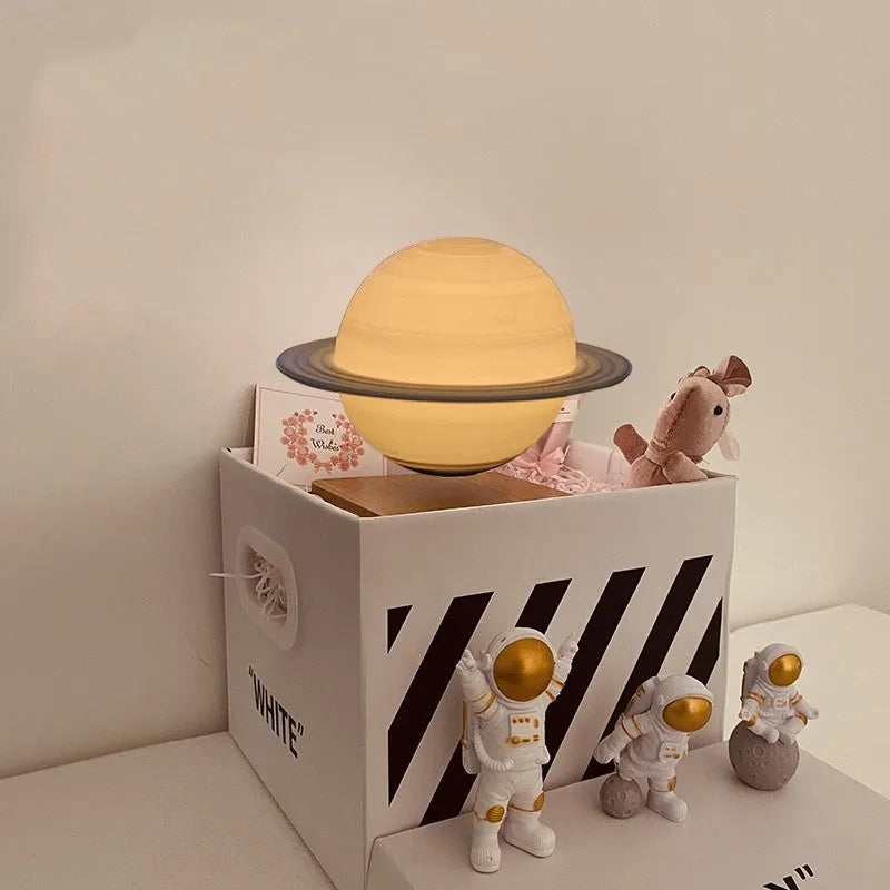 Maglev floating moon planet night light with three astronaut figurines on a dark surface.