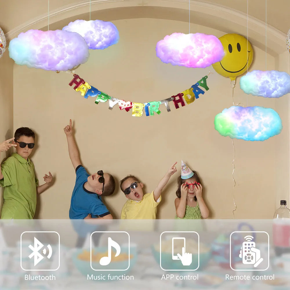 White fabric cloud shaped ambient light with colourful LED lighting, hanging from ceiling with USB cable.