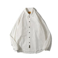 Men's loose-fit cotton cardigan shirt in solid colours on a hanger.