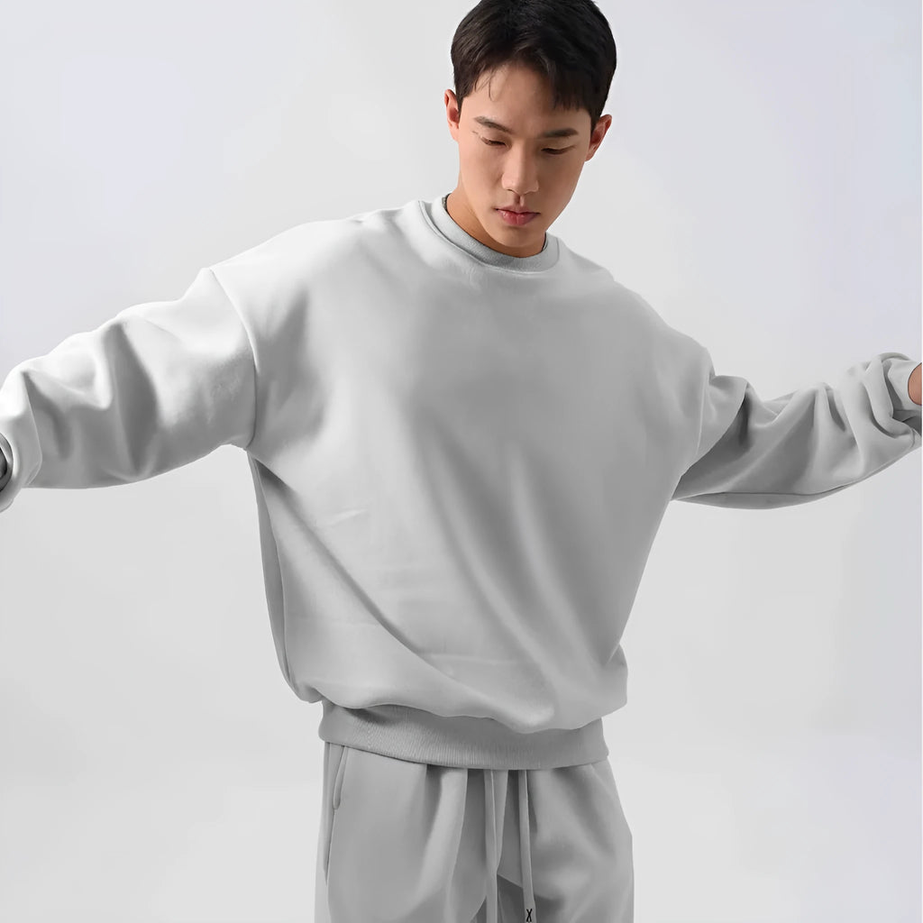 Men's black loose fit polar fleece winter sports suit with long sleeve coat and trousers on a hanger.