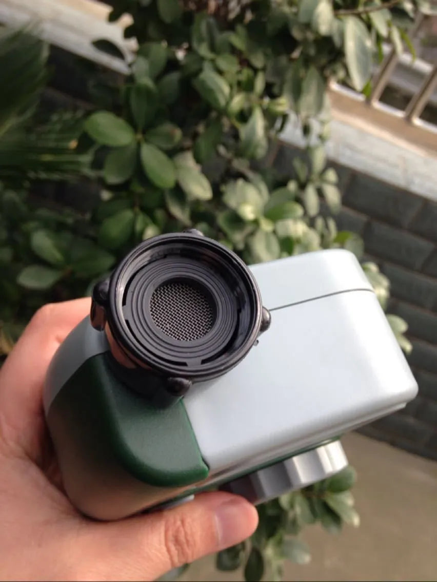 Green programmable digital garden hose timer with dual outlets and large LCD display connected to a faucet.