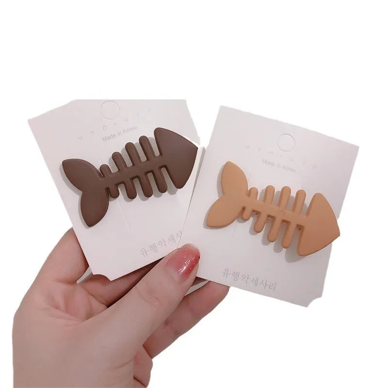 A minimalist fishbone design duckbill clip hair barrette in a muted candy colour.