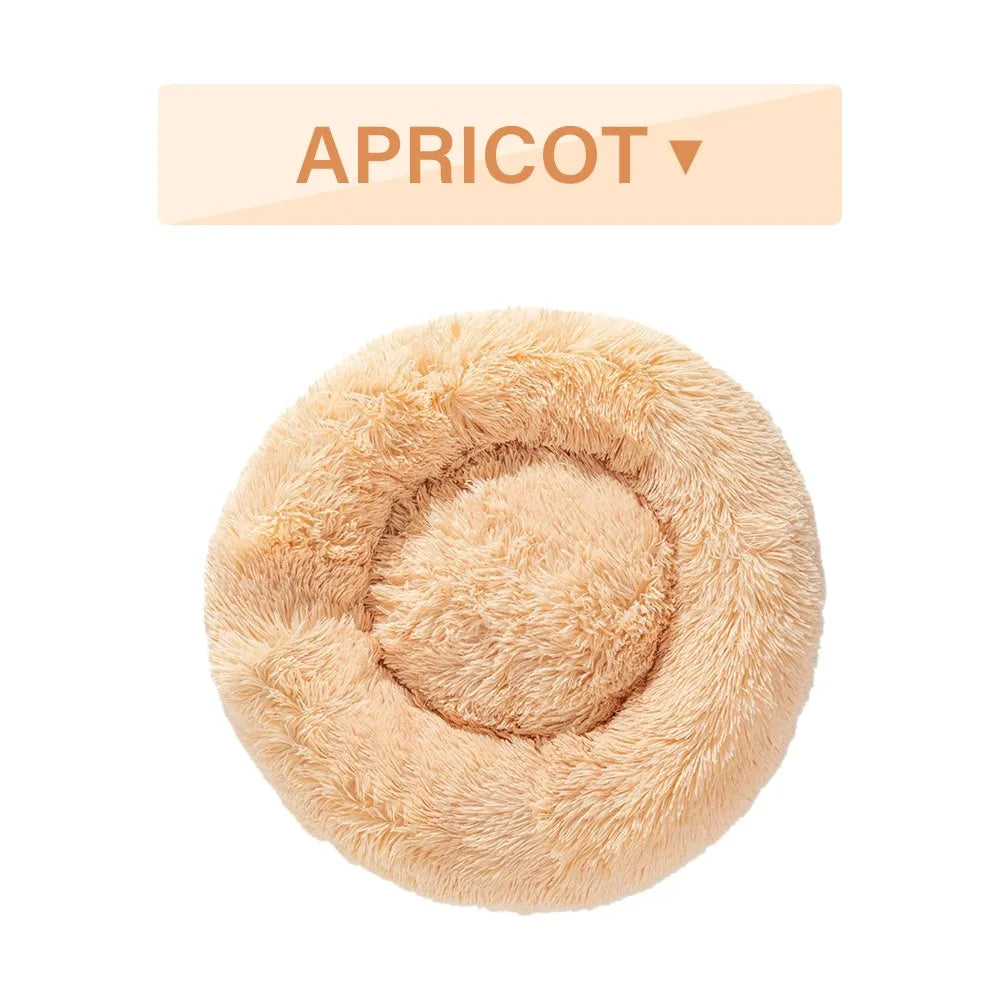Fluffy donut-shaped dog bed in long plush fabric, shown in a light grey colour with raised edges.