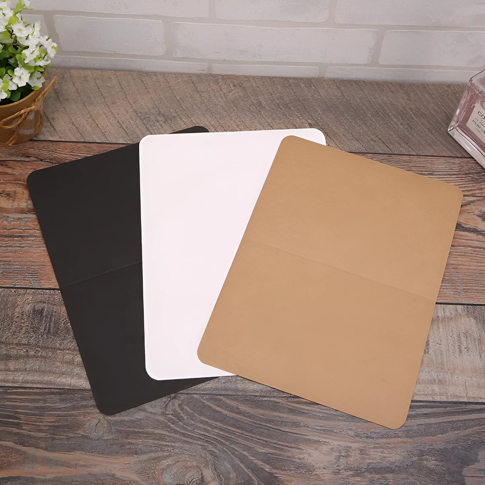 Pack of 100 blank folded kraft paper greeting cards in 10x15cm size, showing black, cowhide brown, and white colour options
