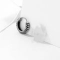 Silver geometric alloy earrings with circular stripe design on a white background.