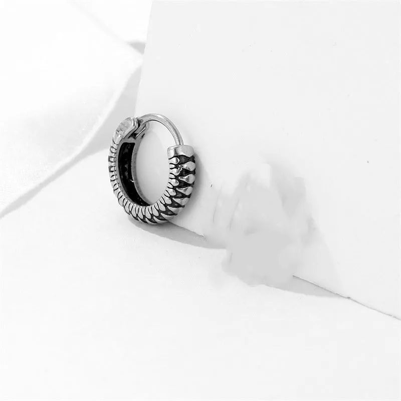 Silver geometric alloy earrings with circular stripe design on a white background.