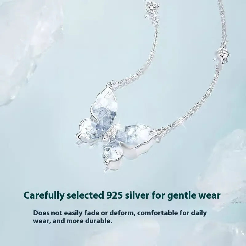 Close-up of a silver necklace with a detailed butterfly pendant on an O-ring chain.