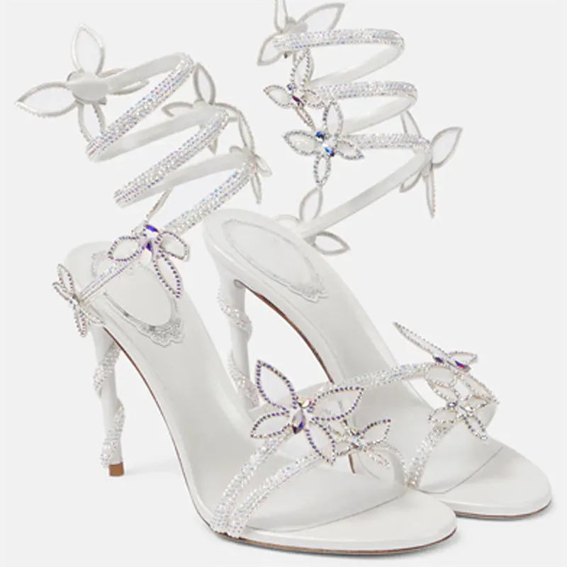 Snake butterfly rhinestone flower stiletto heel Roman sandals in gold with round toe and buckle closure