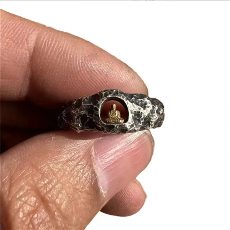 Close-up of a hand-forged copper Buddha ring with grotto design and rock texture on a size 8 finger.