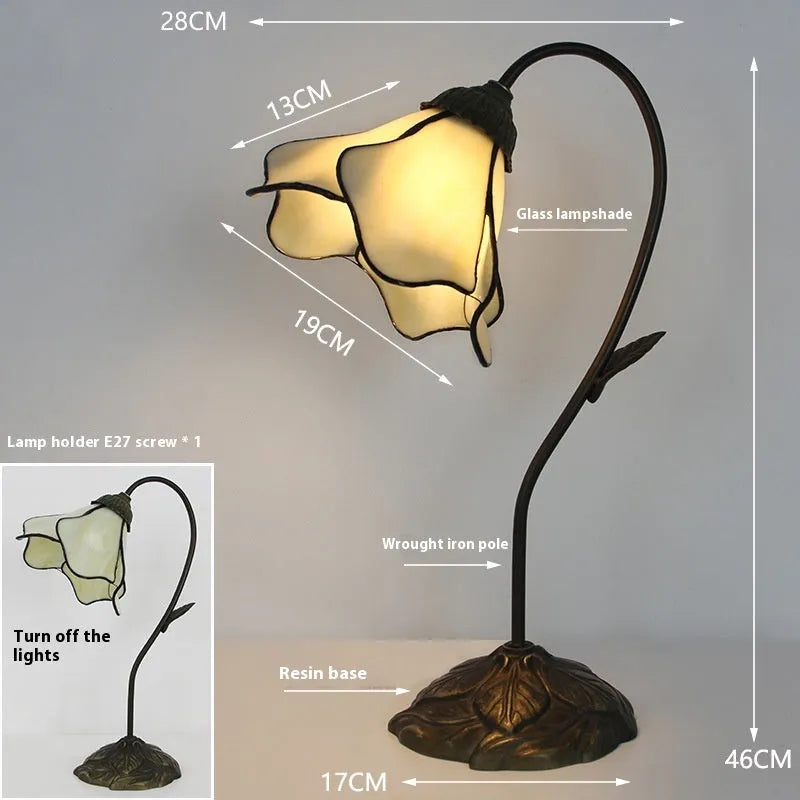 Retro American style table lamp with coloured glass lotus design shade on wooden surface