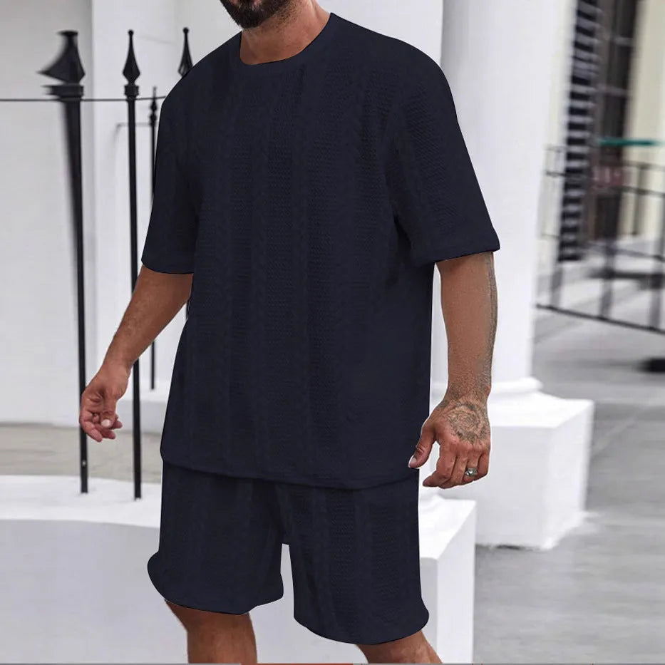 Knitted solid colour short sleeve pullover and matching shorts laid flat.
